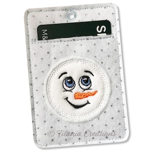 May include: White felt card holder with a snowman face embroidered on the front. The card holder has a clear plastic window for displaying a card. The text "M&S" is visible on the card in the window.