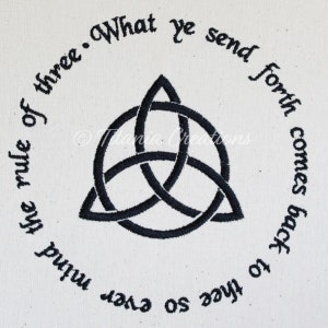 以下が含まれることがあります： 黒と白の刺繍で描かれたトリケトラ、ケルトの結び目のシンボル、そして「What ye send forth comes back to thee so ever mind the rule of three.」というテキストがデザインされています。