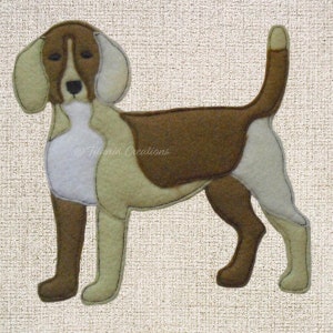 May include: A brown and white felt applique of a beagle dog. The dog is standing with its head turned to the left. The dog has a brown nose and black eyes.