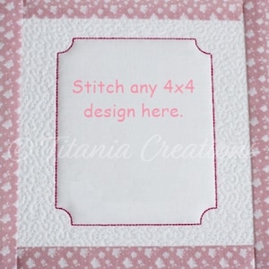 Könnte beinhalten: Weißer Stoff mit einem rosa Blumenmuster. In der Mitte befindet sich ein weißes Quadrat mit einem rosa gestickten Rand und dem Text "Stitch any 4x4 design here."