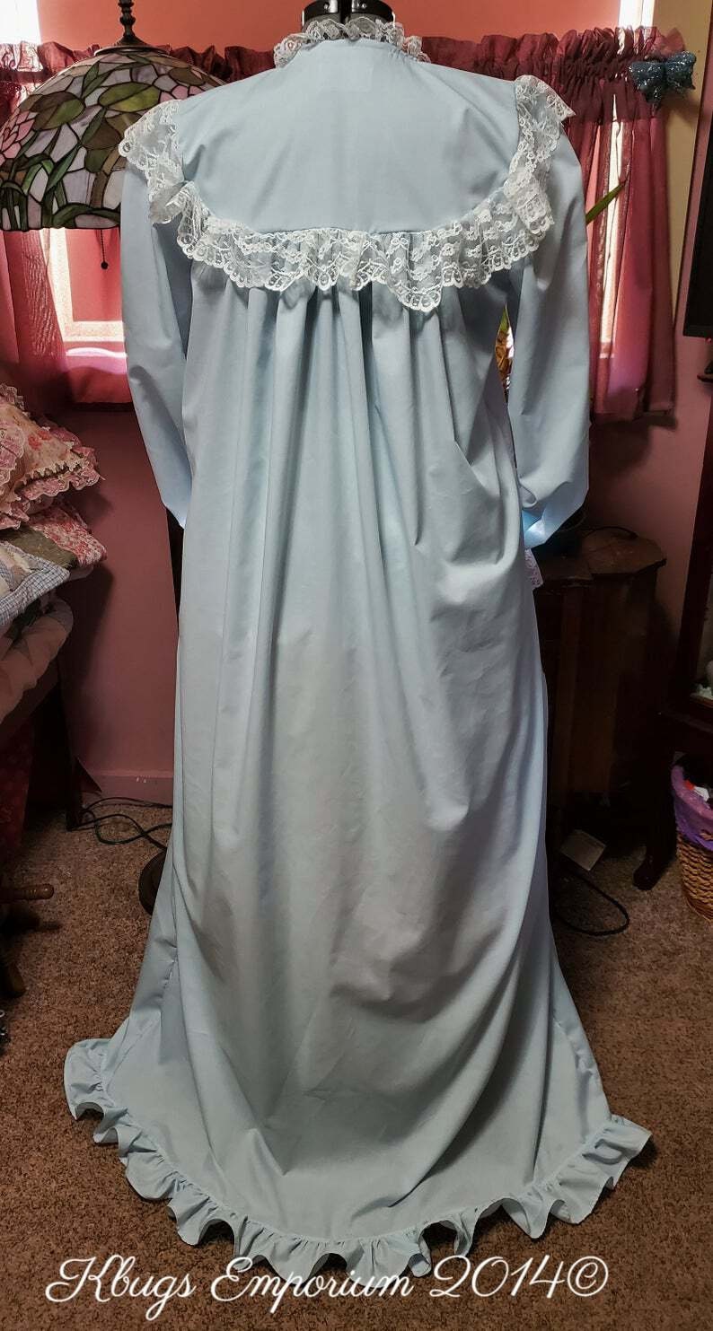Puede incluir: Un camis&oacute;n azul claro con un ribete de encaje blanco alrededor del cuello y las mangas. El camis&oacute;n tiene una falda fruncida y un dobladillo con volantes.