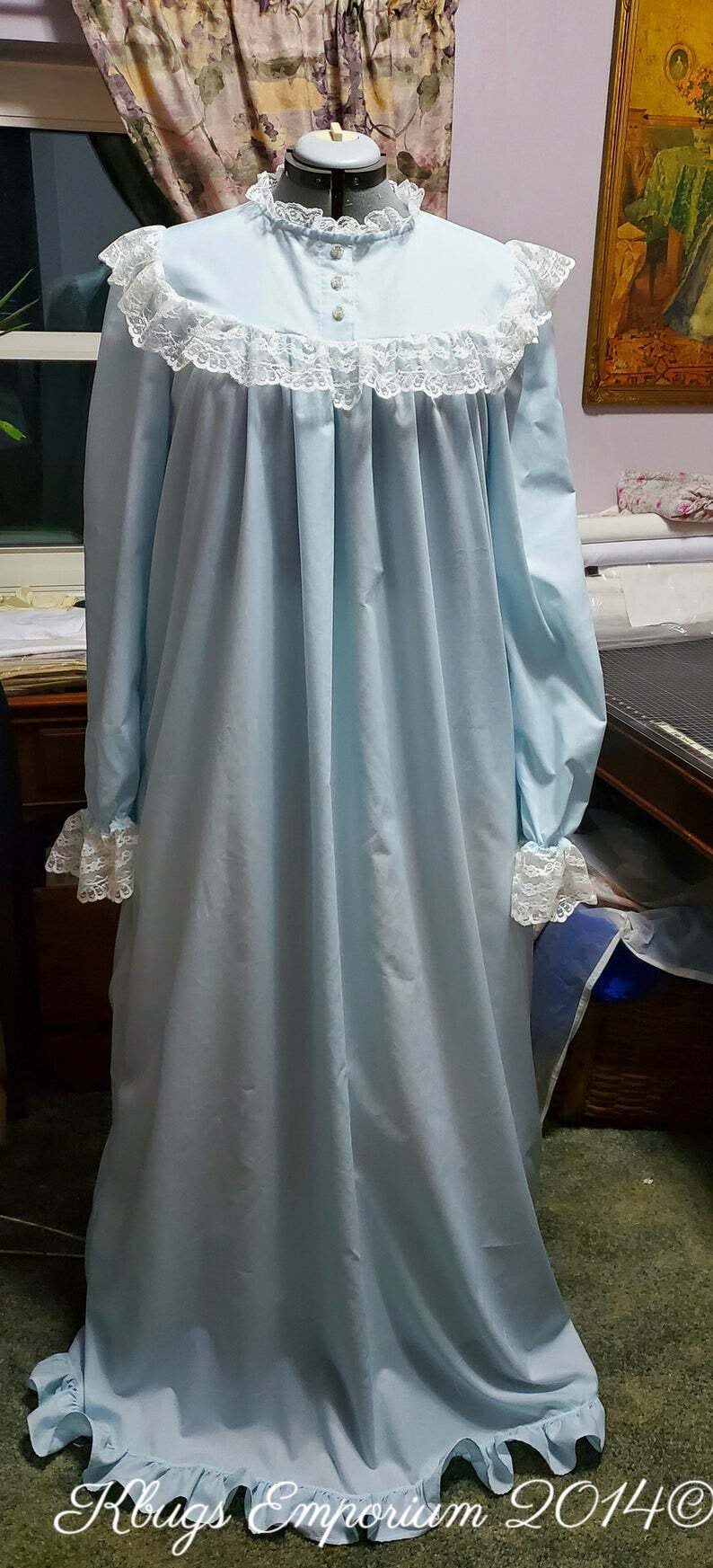 Puede incluir: Un camis&oacute;n azul claro con ribete de encaje blanco alrededor del cuello y las mangas. El camis&oacute;n tiene un corpi&ntilde;o fruncido y un dobladillo con volantes.
