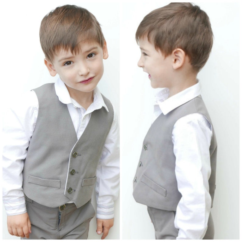 Puede incluir: Un ni&ntilde;o peque&ntilde;o con un chaleco gris y una camisa blanca. El chaleco tiene un ribete blanco y botones. El ni&ntilde;o lleva pantalones grises.