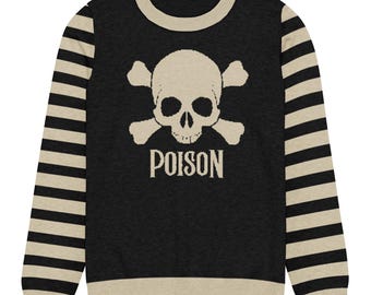 May include: A long-sleeve sweater featuring a black torso with a beige skull and crossbones graphic above the text POISON. The sleeves have horizontal beige and black stripes, and the crew neckline and hem are finished with a beige ribbed trim.