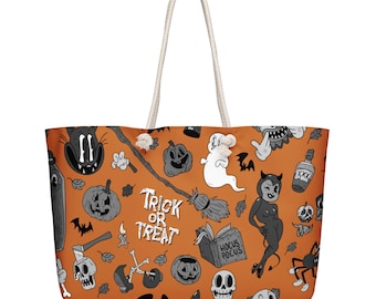 May include: An orange tote bag with white rope handles featuring a black and white cartoon-style Halloween pattern. The print includes pumpkins, a ghost, a witch's broom, a skull, a devil figure, a potion bottle, and the text Trick or Treat.