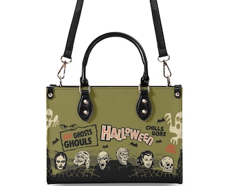 May include: An olive green handbag with black handles and a detachable shoulder strap. The bag features a graphic print with the text HALLOWEEN, GHOSTS, GHOULS, CHILLS, and GORE, alongside illustrations of various monsters, skulls, and bats.