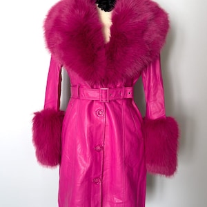 May include: A vibrant pink coat with a faux fur collar and cuffs. The coat features a belted waist, button closures, and a tailored fit. The faux fur trim adds a touch of luxury to this statement outerwear piece.