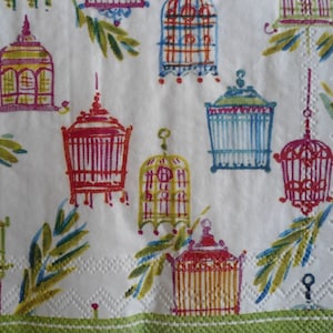 May include: A white background with a repeating pattern of colorful birdcages. The birdcages are in various shapes and sizes, and some are hanging from the ceiling. The background is decorated with green leaves.