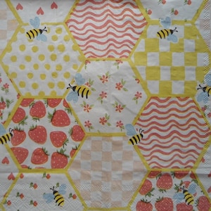 May include: A yellow and white fabric with a honeycomb pattern. Each hexagon features a different design, including strawberries, polka dots, checkered patterns, and wavy lines. Bees are flying around the hexagons.