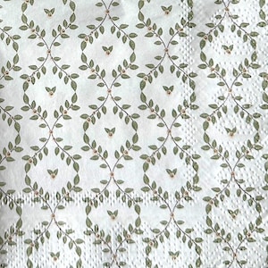 May include: A white paper napkin featuring a repeating trellis pattern of thin brown vines with small green leaves and tiny light pink flowers. The surface has a textured, embossed finish with a visible perforated edge along the right side.