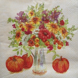 May include: A decorative paper napkin featuring a floral arrangement in a clear vase, with orange pumpkins at the base. The flowers are a mix of red, yellow, and purple, with green foliage. The pumpkins are a vibrant orange.