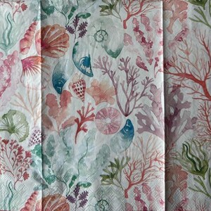 May include: A white background with a watercolor pattern of pink, red, and green coral and seashells.