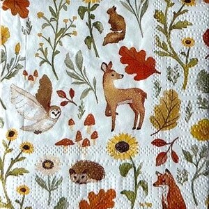 May include: White paper napkin with a repeating pattern of woodland creatures and foliage. The design includes a deer, owl, fox, squirrel, hedgehog, sunflowers, mushrooms, and autumn leaves in shades of brown, orange, and yellow.