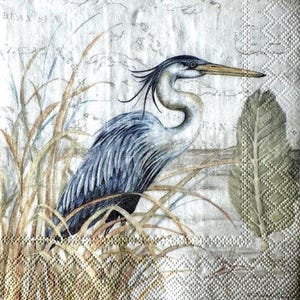 May include: A square paper napkin featuring a detailed illustration of a blue heron standing among tall grasses. The background displays a faint, vintage-style map with text including "BEAN SEA" and "CARIBBEAN". The napkin has a textured border.