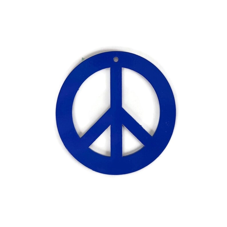 May include: A blue peace sign ornament. The peace sign is a circle with a stylized dove inside.