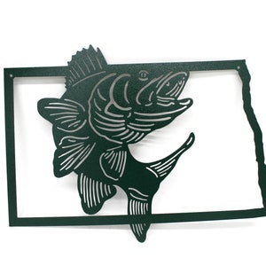 May include: A dark green metal wall art piece featuring a leaping fish silhouette within the outline of the state of Nebraska. The fish has detailed fins and scales, and the state outline is a simple, clean design.