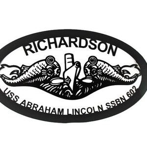 May include: Black and white oval metal sign with the text "RICHARDSON USS ABRAHAM LINCOLN SSBN 602" and a stylized image of a submarine with two dolphins.