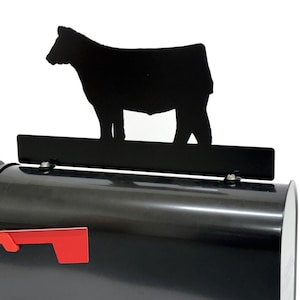 May include: A black mailbox with a red flag and a black cow silhouette on top. The mailbox has a standard shape and size, with a glossy finish. The cow silhouette is a simple design.
