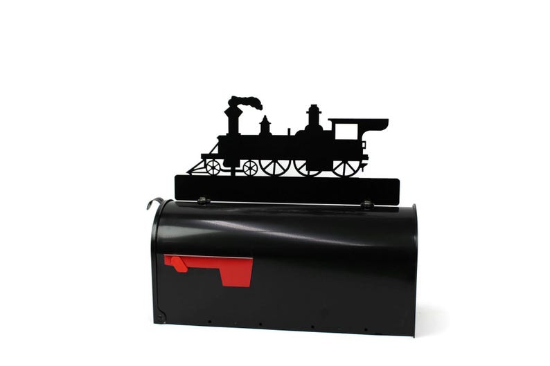 May include: A black metal mailbox with a red flag and a decorative black silhouette of a steam train on top. The mailbox is a classic design, perfect for a home or business.