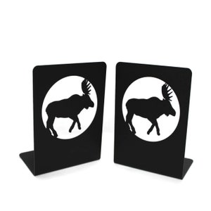 May include: A pair of black metal bookends featuring a moose silhouette in a circle. The bookends are a decorative and functional addition to any bookshelf.