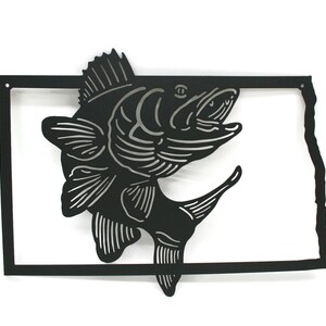 May include: Black metal wall art featuring a leaping fish design within a rectangular frame. The fish is detailed with silver accents, and the frame is shaped like the outline of a state. A decorative piece for fishing enthusiasts.