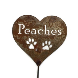 Peaches is the name with 2 paw prints below on the heart stake.