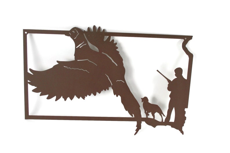 May include: A brown metal wall art piece depicting a pheasant in flight, a hunter with a rifle, and a dog. The artwork is in the shape of a state outline, with a rectangular border.