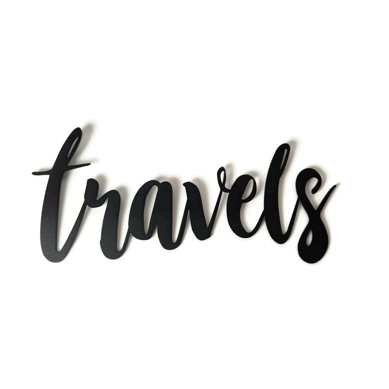 May include: Black metal wall decor with the word "travels" written in a cursive font.