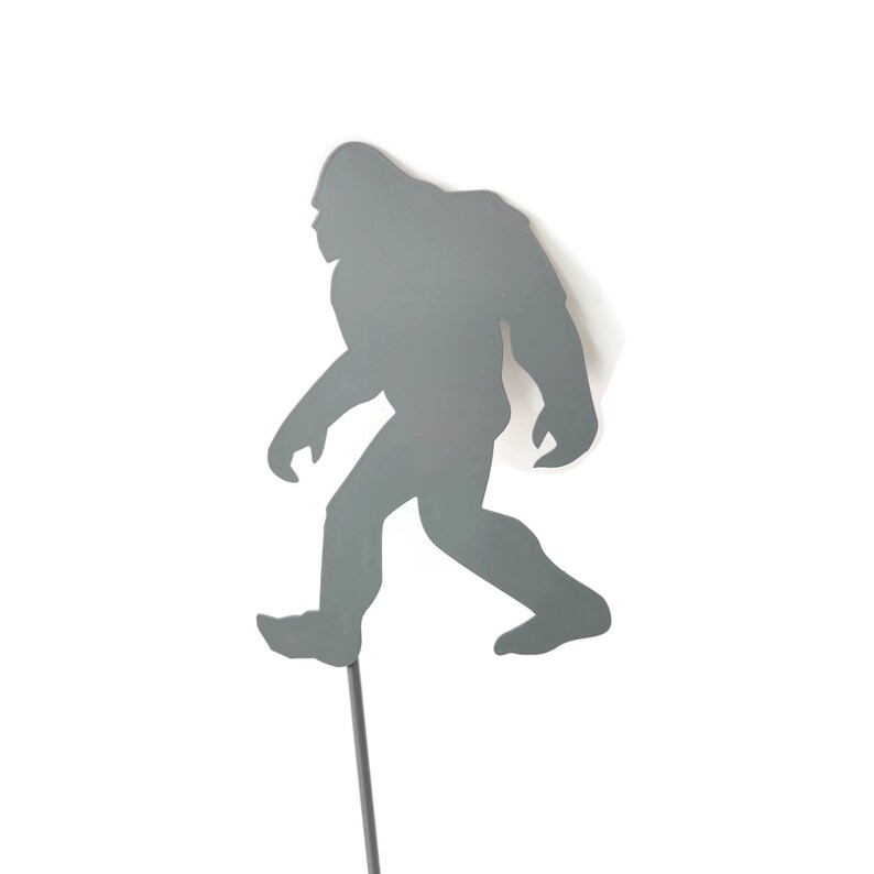 May include: A white ceramic mug with a black handle and the text "But First, Coffee" in a bold, black font. The mug is set against a blurred background, suggesting a cozy setting.