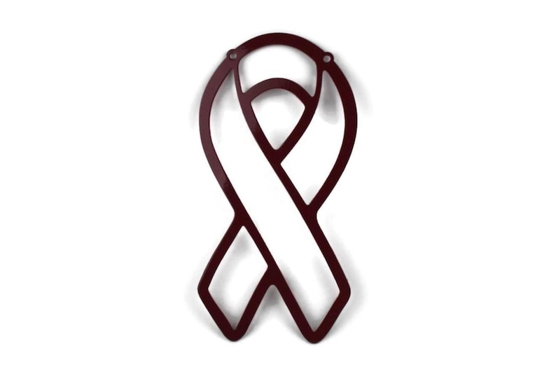 May include: A burgundy metal ribbon cutout, a symbol of awareness. The ribbon has a classic looped design with a central opening. Two small holes are at the top for hanging. The cutout is displayed against a white background.