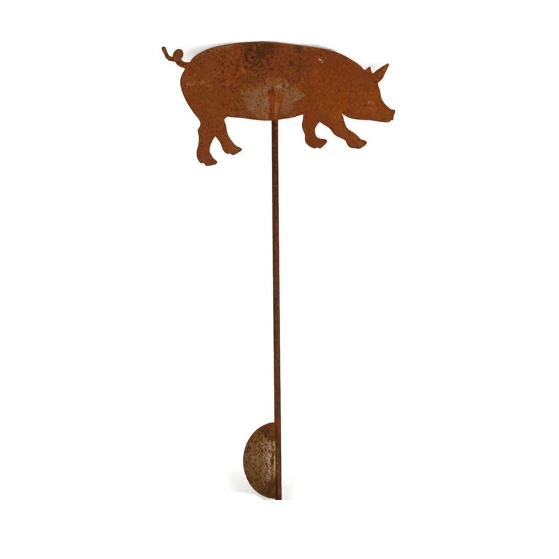 May include: A rusty metal pig silhouette mounted on a long, thin metal rod. The pig is facing right and has a curled tail. The rod is attached to a round metal base.