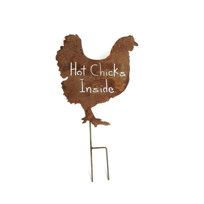 May include: Rusty metal chicken silhouette with the text "Hot Chicks Inside" on the body. The chicken is attached to a metal stake for outdoor use.