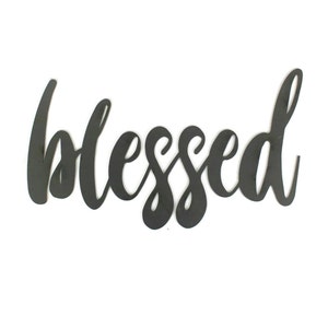 May include: Black metal wall decor with the word "blessed" written in a cursive font.