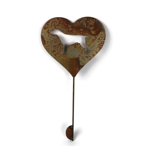May include: A rustic metal garden stake featuring a heart shape with a dog silhouette cutout. The stake has a weathered, brown finish and a long stem with a small, rounded end. Ideal for adding a touch of charm to any garden or outdoor space.