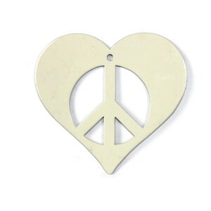 May include: A white metal heart-shaped charm with a peace sign cut out in the center.
