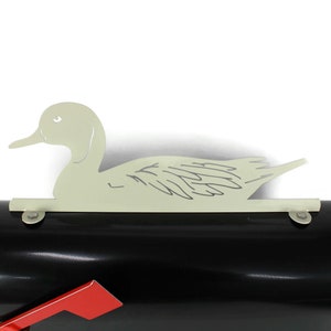 May include: A black mailbox with a red flag and a white metal duck silhouette on top.