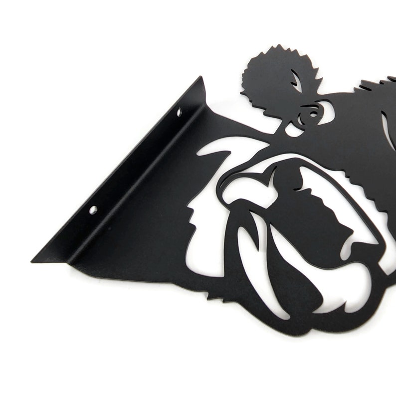 May include: Black metal shelf bracket with a bulldog silhouette. The bracket has two holes for mounting.