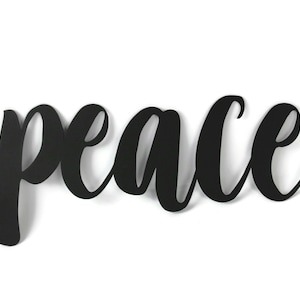 May include: Black metal wall decor with the word "peace" written in a cursive font.