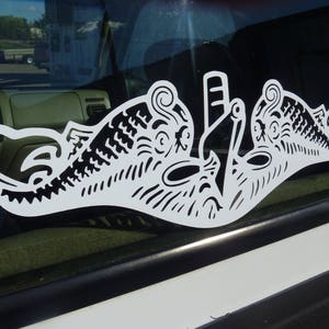 May include: A white vinyl decal of a stylized submarine with a detailed design. The decal is on a car window.
