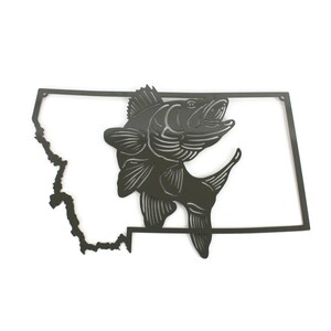 May include: Metal wall art featuring a silhouette of a fish jumping out of the water, with the outline of the state of Montana behind it. The artwork is painted in a dark grey colour.
