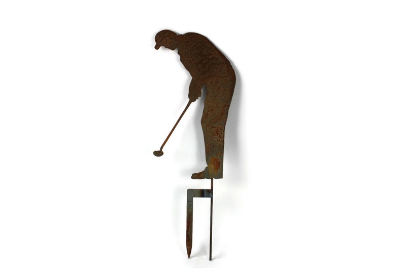 May include: A rusty metal lawn ornament depicting a golfer in mid-swing. The figure is attached to a stake for easy placement in a garden or yard. The golfer is approximately 18 inches tall.