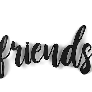 May include: Black metal wall decor with the word "friends" written in a cursive font.
