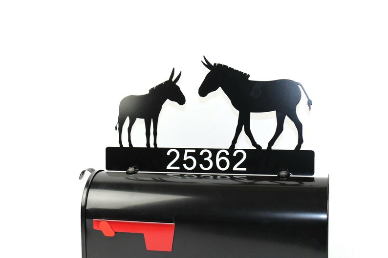 Puede incluir: Tope de buz&oacute;n de metal negro con dos siluetas de burro y el n&uacute;mero de casa 25362. El tope est&aacute; montado en un buz&oacute;n negro.