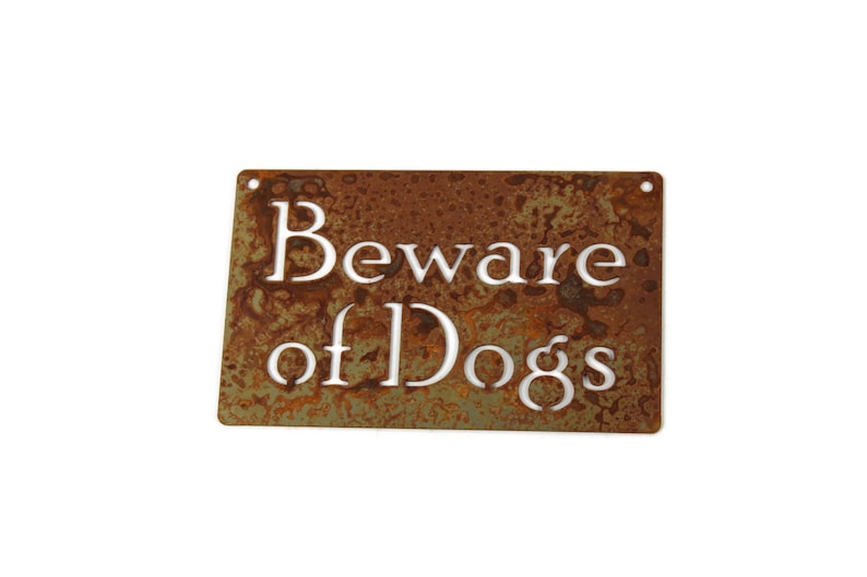 May include: A rusty metal sign with the text "Beware of Dogs" in white lettering.