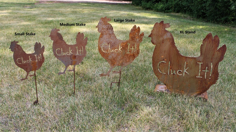 May include: Four metal chicken silhouettes with the text "Cluck It!" on each. The chickens are different sizes, with the largest one standing on a base and the smaller ones on stakes. The chickens are rusty brown in color.