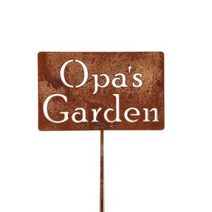 May include: A rectangular, rusty brown metal garden sign with the words "Opa's Garden" cut out in white lettering. The sign is mounted on a thin, metal stake, perfect for a garden or yard. The sign is designed to be placed in the ground.