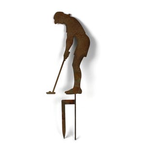 May include: A rusty metal lawn ornament depicting a golfer in mid-swing. The figure is attached to a stake for easy placement in a garden or yard. The golfer is wearing shorts and a hat.