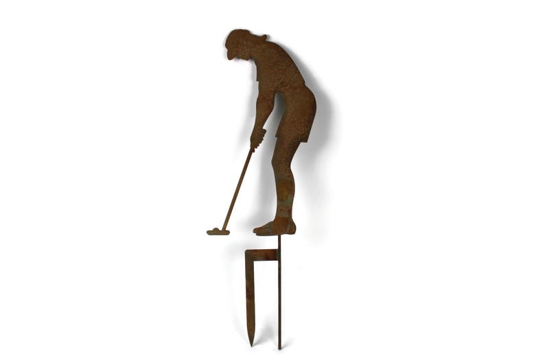 May include: A rusty metal lawn ornament depicting a golfer in mid-swing. The figure is attached to a stake for easy placement in a garden or yard. The golfer is wearing shorts and a hat.
