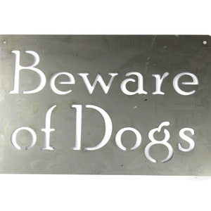 May include: A silver metal sign with the words "Beware of Dogs" cut out in white.