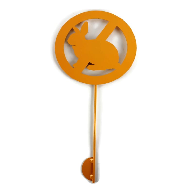 May include: A gold metal hook shaped like a no rabbits sign. The sign is a circle with a diagonal line through it and a rabbit silhouette inside.